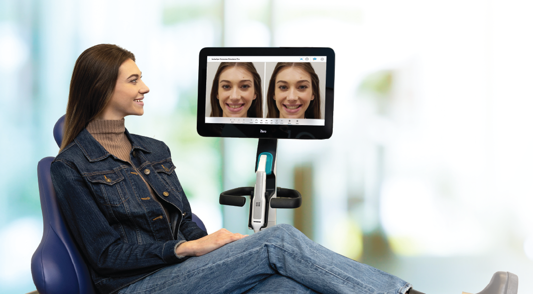 Patient viewing an Invisalign Outcome Simulator preview beside an iTero scanner